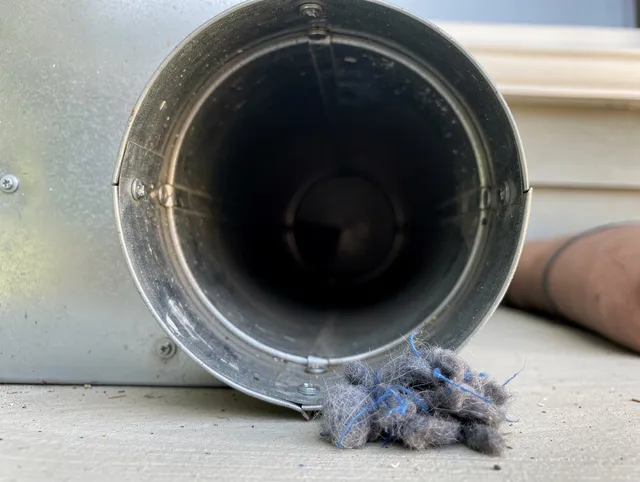 West Warwick Dryer Vent Cleaning technician using specialized equipment to clear severe dryer vent blockage in West Warwick